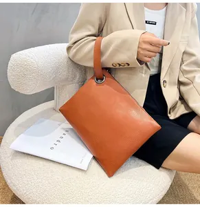 Detailed view of brown lizard texture on a flat envelope clutch bag with wrist strap