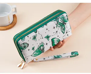 Detailed view of long double-zipper wallet with green butterfly print and wrist strap