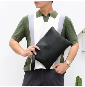 Close-up of black lizard texture clutch bag with silver zipper and wrist strap detail