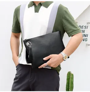 Close-up of black lizard texture envelope bag with wrist strap and metal zipper detail