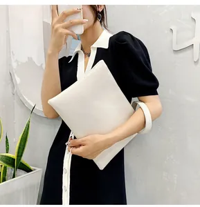 Detailed texture of white faux crocodile pattern envelope clutch bag with leather wristlet