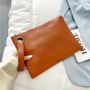 Brown lizard pattern leather clutch bag with silver metal eyelet and wrist strap