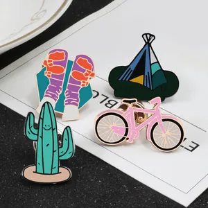 Cartoon enamel pin set featuring cactus, bicycle, camping tent, and socks on white card