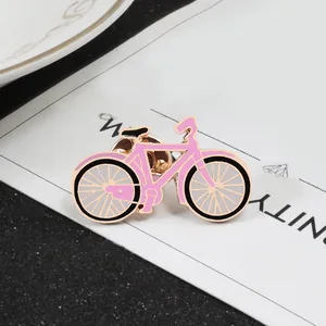 Pink cartoon bicycle enamel brooch with gold trim and butterfly clutch on card