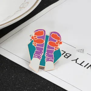 Detail view of cartoon enamel pin showing purple socks and orange sneakers on blue base