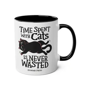 Close-up of ceramic cat mug with black handle and Time Spent With Cats quote