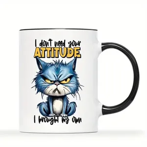 Detail view of white ceramic mug with blue angry cat illustration and humorous slogan