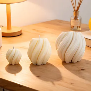 Three sizes of spiral wave scented candles on wooden table with warm lighting