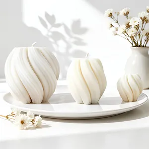 Three minimalist spiral wave scented candles in various sizes on white ceramic tray