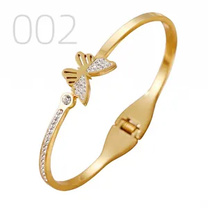 Close-up of gold stainless steel butterfly bangle with pavé crystals and spring hinge