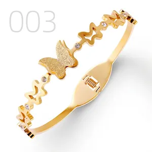 Close-up of gold stainless steel butterfly bangle with matte finish and rhinestones