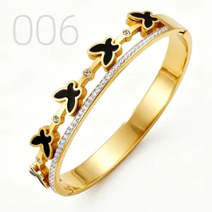 Close-up of gold butterfly bangle with black enamel and sparkling zircon accents