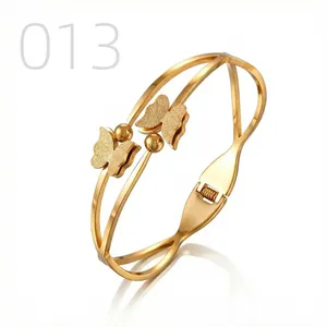 Detailed macro view of gold-plated butterfly bangle with frosted texture and snap closure