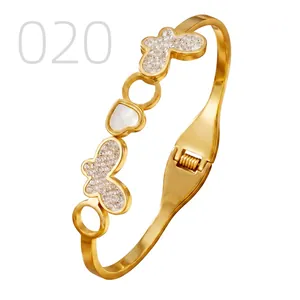 Detail of gold butterfly and heart bangle with cubic zirconia and mother of pearl