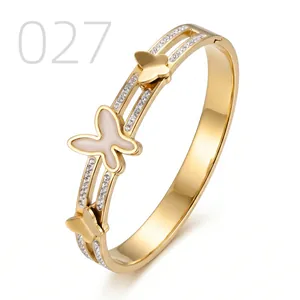 Macro detail of gold butterfly cuff bracelet featuring pavé zircon and white enamel butterfly