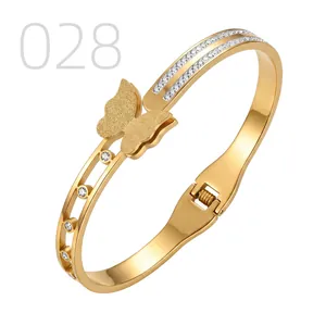 Detail of gold butterfly bangle with matte finish, double row crystals and polished steel