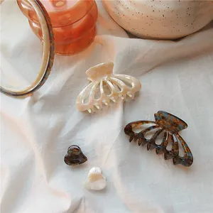 Detail showing cream and tortoiseshell acetate hair claws with small heart clips