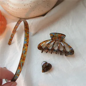Detail view of tortoiseshell acetate hair set including headband, claw clip and heart clip
