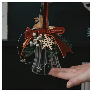 Detail of vintage glass Christmas bell with velvet bow and wooden reindeer ornament