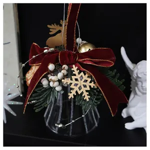 Close-up of velvet bow Christmas ornament with wooden deer and pine needles