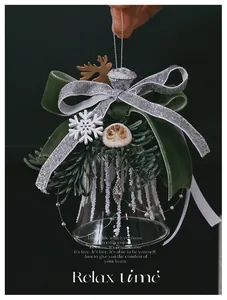Detail of Christmas glass bell with velvet bow pine branches and festive decorations