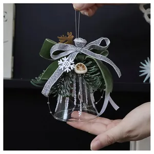 Detail of Christmas glass bell with velvet bow, pine branches, and golden elk silhouette