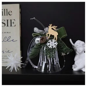 Detailed view of a glass Christmas bell with pine needles and green velvet bow