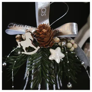 Macro shot of Christmas glass bell with pine cone, ribbon bow and wooden horse detail