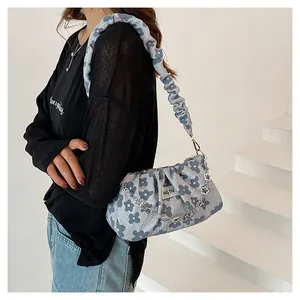 Detail of floral ruched cloud bag with ruffled shoulder strap and silver floral chain link
