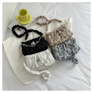 Detailed shot of pleated floral jacquard armpit bags in white, black, khaki and blue colors
