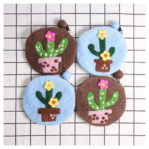Top view of handmade felt cactus coin purses in light blue and brown with wool ball trim