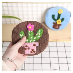 Detailed texture of handmade wool felt coin purse with cactus and floral embroidery