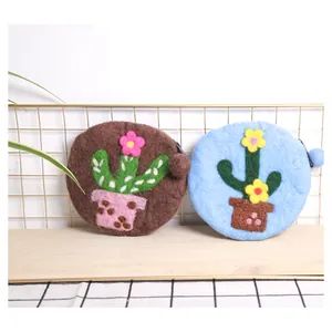 Detail view of handmade wool felt cactus coin purses with plush ball zippers