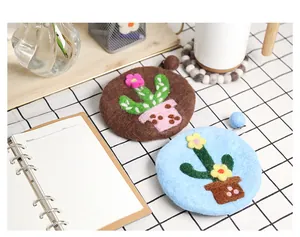 Macro detail of handmade wool felt coaster featuring 3D cactus flower embroidery