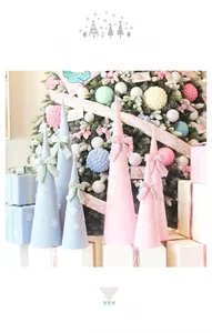 Détails d'ornements de Noël coniques rose et bleu avec des nœuds et des motifs flocons