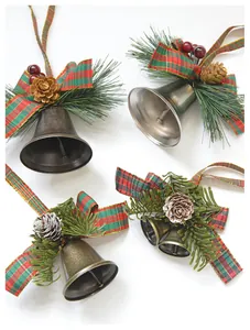 Detail of Christmas bell ornaments with tartan bows, pine cones and red berries