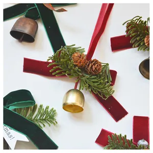 Detail of Christmas velvet bow ornaments with pine needles, cones and golden bells