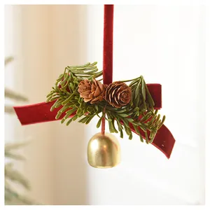Close-up of a Christmas bell pendant with red velvet ribbon, pine needles and pinecones