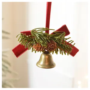 Close-up of Christmas decoration with red velvet bow, pine cones and a golden bell