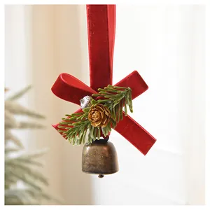 Detail of Christmas velvet bow ornament with pine needles, cones and a brass bell