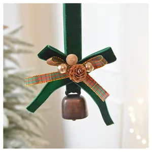 Detail of Christmas velvet bow ornament with pine cone and vintage metallic bell charm