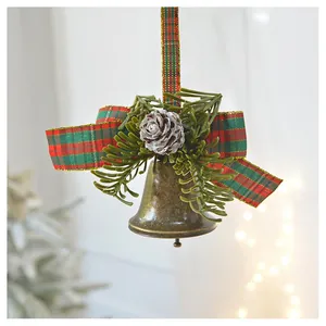 Macro detail of Christmas bell with pine cone and red-green plaid ribbon bow