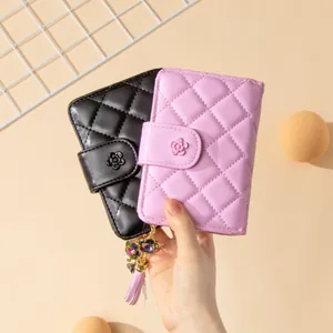 Close-up of quilted PU leather wallets with floral snap and decorative tassel accents