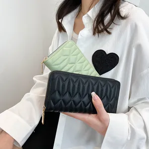 Detail of long quilted PU leather wallet featuring zipper closure and diamond texture