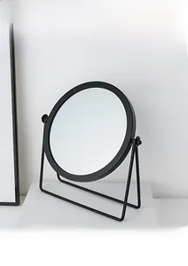 Detailed macro view of black metal swivel frame on a minimalist desktop makeup mirror