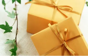 Detail of yellow gift boxes wrapped with shiny satin ribbons and elegant bows