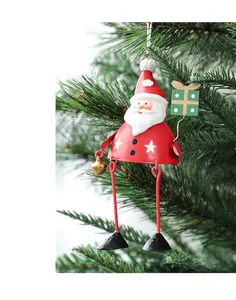 Detail of metal Santa Claus ornament with red finish and stars on a green Christmas tree