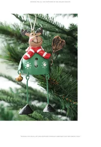 Close-up of a festive painted metal reindeer hanging ornament on a green Christmas tree