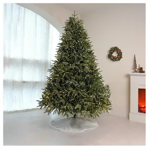 Close-up of a white faux fur Christmas tree skirt under a lighted evergreen tree