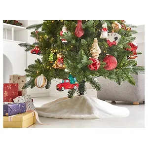 Detail view of plush white faux fur Christmas tree skirt and assorted festive ornaments